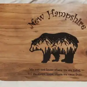 Custom engraved New Hampshire bear-shaped wooden charcuterie board with home quote.