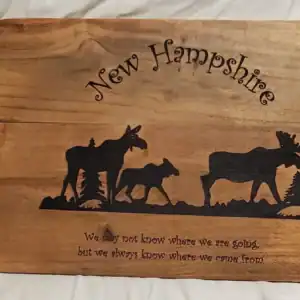 Moose family engraved on wooden charcuterie board, perfect for New Hampshire decor.