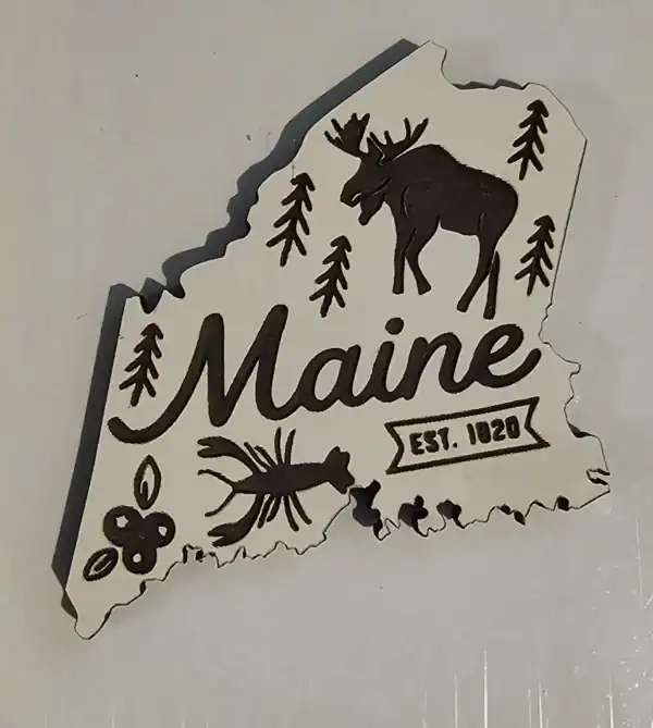 Maine state laser engraved magnet with moose, pine trees, and lobster design. Perfect for souvenirs.