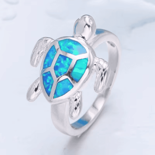 Vibrant blue opal turtle jewelry ring, handcrafted silver design, sea-inspired accessory.